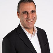 A smiling man in a suit, suggesting professionalism, aligns with WeNatal's focus on prenatal health and wellness products for men and women.